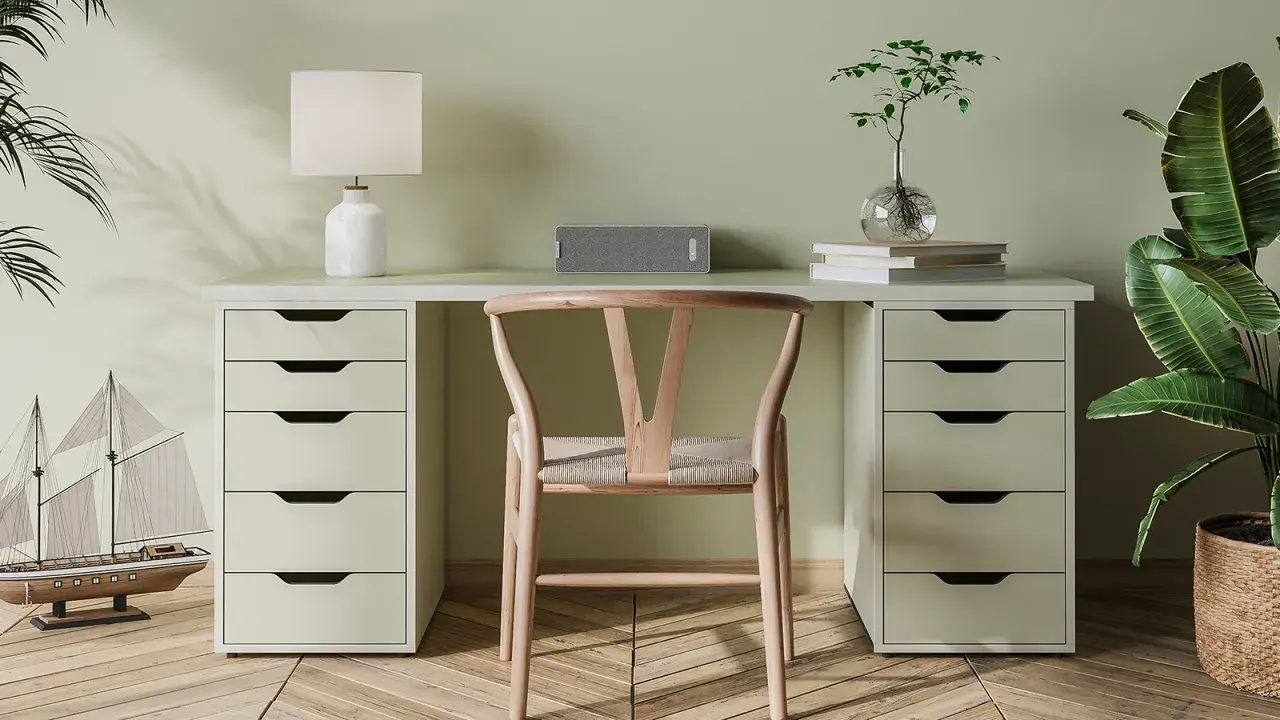 Un bureau DIY épuré avec une chaise en bois, une lampe, un haut-parleur et une plante.