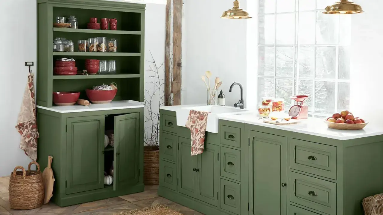 Ambiance rustique pour cette rénovation vieille cuisine. Meubles verts, vaisselle rouge, et lumière naturelle.