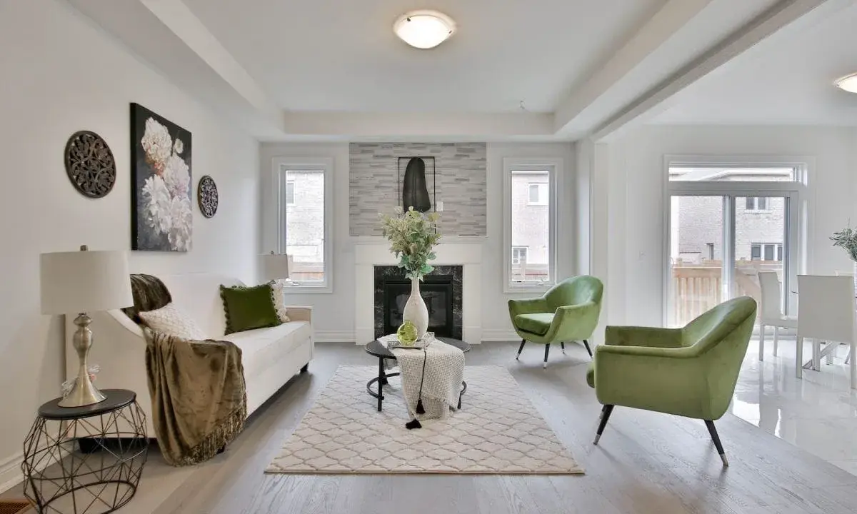 Salon moderne avec canapé blanc, fauteuils verts et cheminée. Idéal pour un conseil décoration intérieur gratuit.