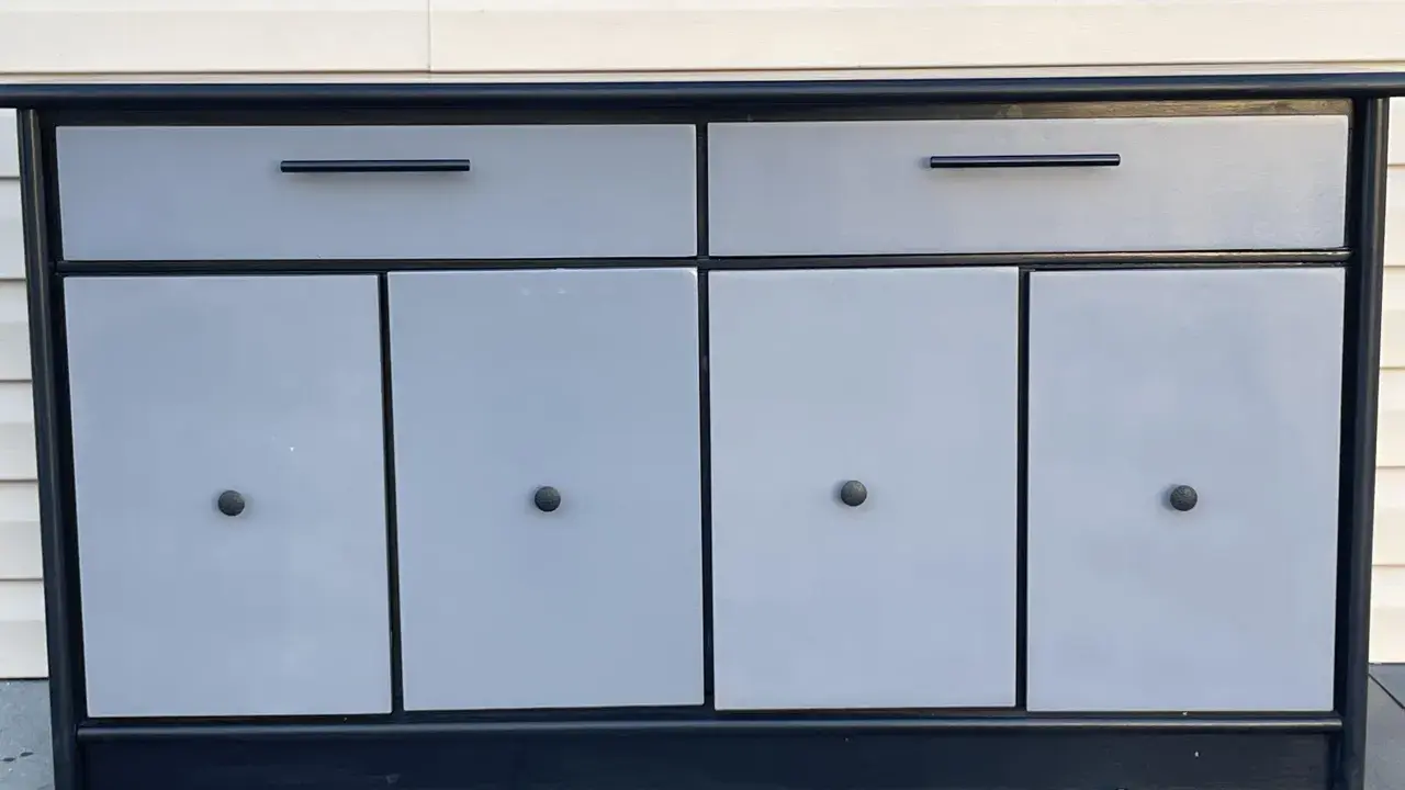 Meuble bas gris et noir avec deux tiroirs et quatre portes. Idéal pour savoir comment vendre ses meubles rapidement.