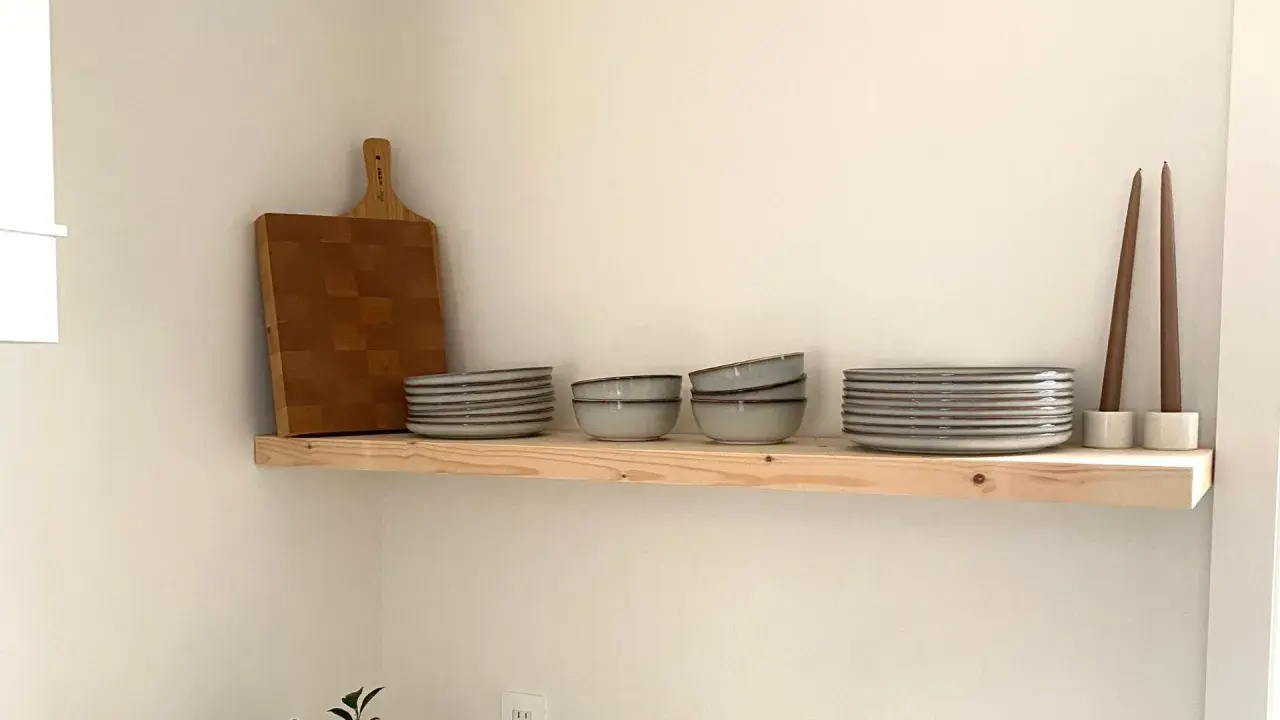 Étagère en bois brut, parfaite pour une cuisine de style **diy etagere bois**. Elle accueille une planche à découper, des assiettes, des bols et des bougies.
