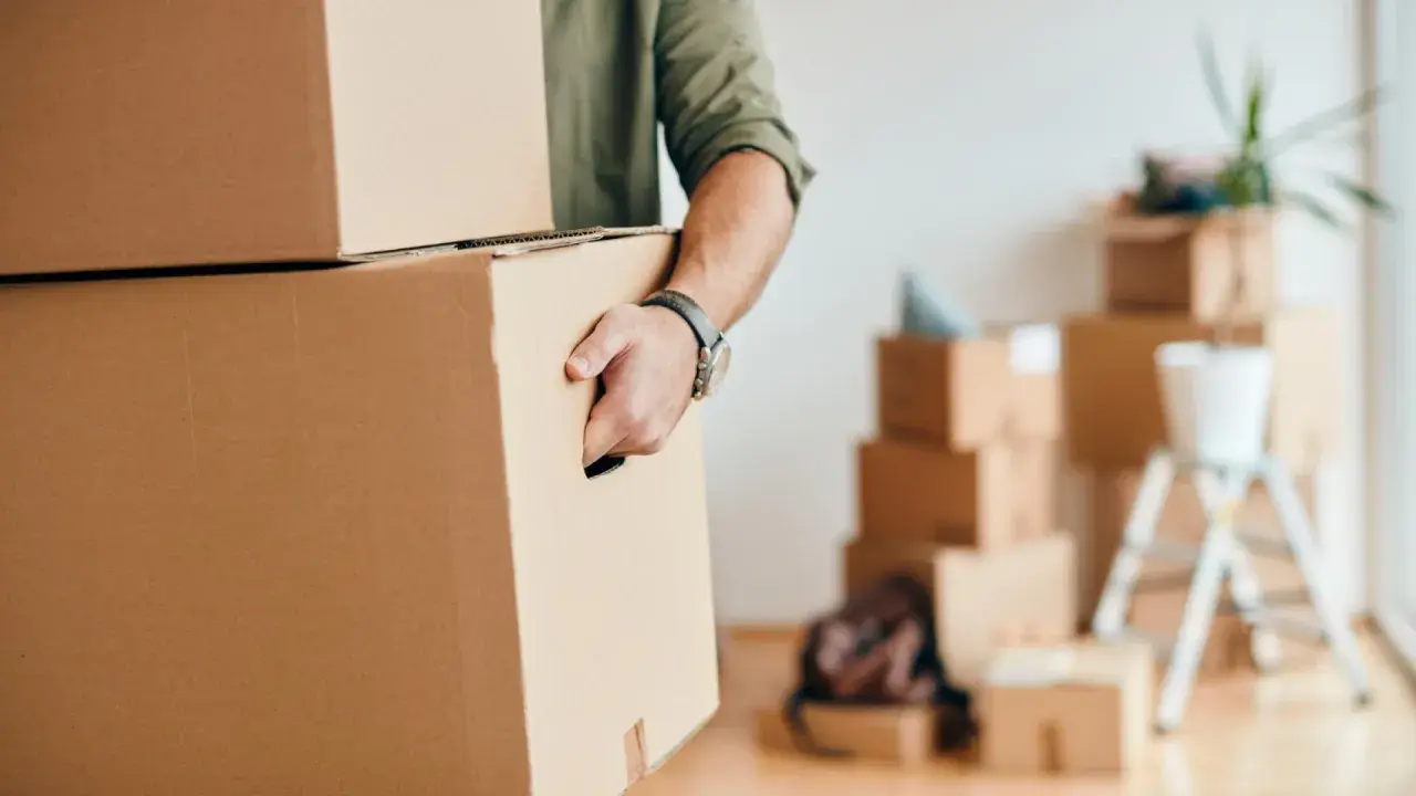 Homme portant des cartons, prêt pour une organisation déménagement longue distance.