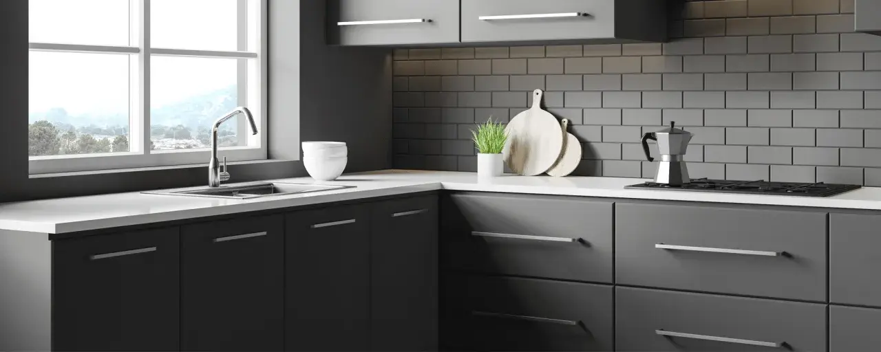 Cuisine moderne avec meubles gris foncés, carrelage métro anthracite et plan de travail blanc. Idéal pour un projet de renover meuble cuisine.