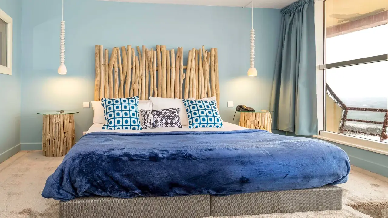 Tête de lit bois à faire soi-même, ambiance bord de mer avec coussins bleus et couverture marine.