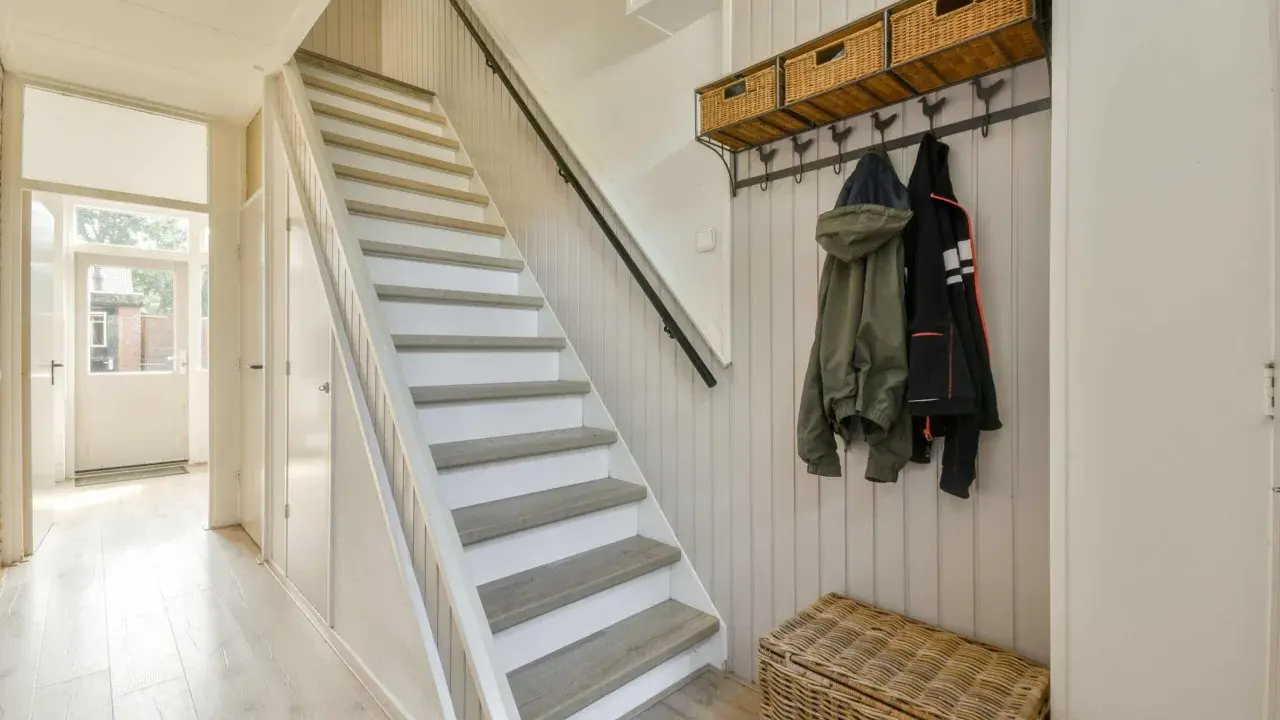 Escalier blanc et gris, avec des marches en bois clair. Une idée pour peindre une cage d'escalier quelle couleur ? Ce style épuré est très tendance.