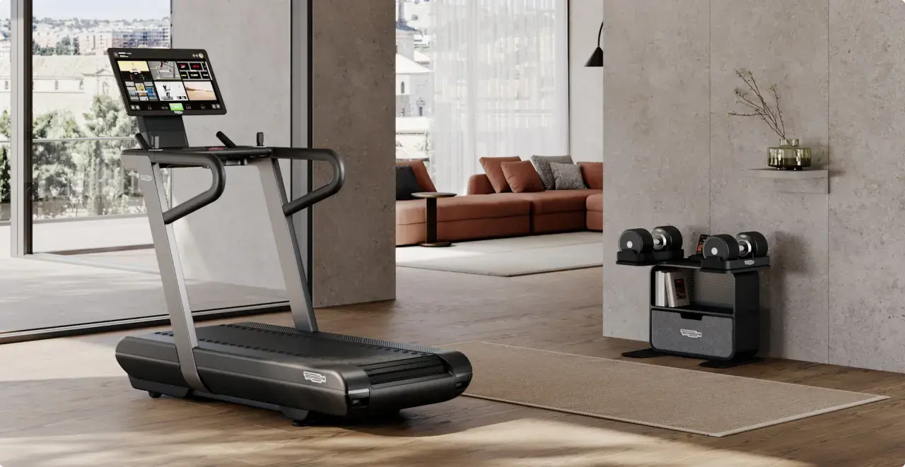 Un tapis de course et des haltères ajustables pour faire une salle de sport chez soi. Un espace moderne et fonctionnel pour le fitness à domicile.