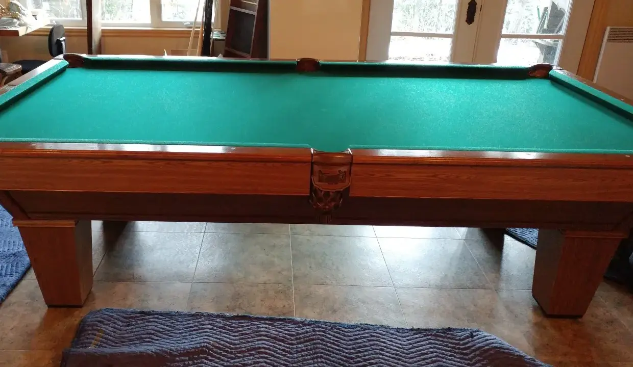 Table de billard français en bois avec tapis vert, prête pour le démontage.