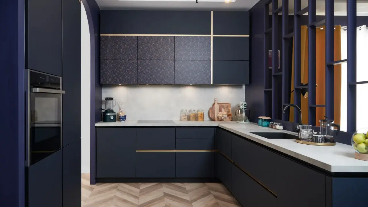 Cuisine moderne bleu nuit avec plan de travail en béton ciré. Une belle idée aménagement cuisine avec des portes à motifs géométriques et des touches dorées.
