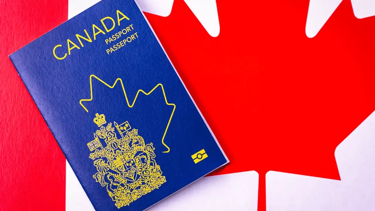 Un passeport canadien bleu sur le drapeau du Canada. Le début d'une nouvelle vie, une aventure pour déménager au Canada.
