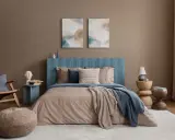 Une peinture de chambre adulte apaisante avec un lit douillet, un fauteuil en rotin et des œuvres d'art abstraites.