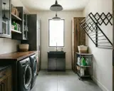 Ample space in this arrière cuisine, with two washers, a large sink, and plenty of storage. A drying rack is mounted on the wall.