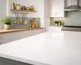 Un plan de travail de cuisine blanc et spacieux, idéal pour organiser vos ustensiles et préparer vos repas.