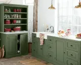 Ambiance rustique pour cette rénovation vieille cuisine. Meubles verts, vaisselle rouge, et lumière naturelle.