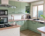 Cuisine vert d'eau et bois, avec des armoires douces, un plan de travail en bois chaleureux et des touches de blanc. Un espace invitant pour cuisiner et partager.