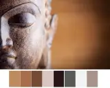 Gros plan sur le visage d'une statue de Bouddha aux tons terreux, avec une palette de couleurs apaisantes.