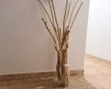 Un vase en verre rempli de bois flotté, parfait pour une déco bois flotté à faire soi-même.