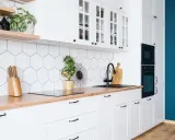 Cuisine moderne et lumineuse avec carrelage hexagonal blanc, plan de travail en bois et meubles blancs. Idéal pour refaire sa cuisine petit budget.