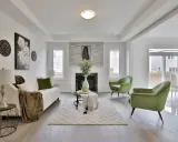 Salon moderne avec canapé blanc, fauteuils verts et cheminée. Idéal pour un conseil décoration intérieur gratuit.