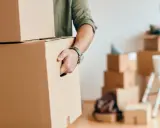 Homme portant des cartons, prêt pour une organisation déménagement longue distance.