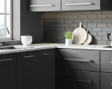 Cuisine moderne avec meubles gris foncés, carrelage métro anthracite et plan de travail blanc. Idéal pour un projet de renover meuble cuisine.