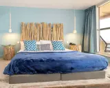 Tête de lit bois à faire soi-même, ambiance bord de mer avec coussins bleus et couverture marine.