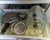 Tiroir de cuisine bien organisé avec une astuce pour ranger les couvercles de casseroles et poêles en verre et métal.