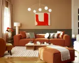 Salon chaleureux avec canapé orange, fauteuil assorti et tapis graphique. Un excellent conseil couleur peinture pour une ambiance cosy.