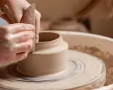 Mains argileuses façonnant un vase sur un tour, une scène d'inspiration peinture céramique.