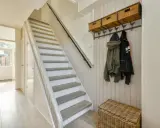 Escalier blanc et gris, avec des marches en bois clair. Une idée pour peindre une cage d'escalier quelle couleur ? Ce style épuré est très tendance.