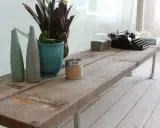 Une table basse rustique, idéale pour savoir que faire avec des vieilles planches de bois. Elle est décorée d'une machine à écrire vintage, de vases et d'une bougie.