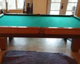 Table de billard français en bois avec tapis vert, prête pour le démontage.