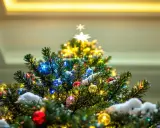 Un sapin de Noël décoré de boules colorées, de guirlandes lumineuses et d'une étoile scintillante. Un guide pour savoir comment faire un beau sapin.