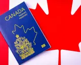 Un passeport canadien bleu sur le drapeau du Canada. Le début d'une nouvelle vie, une aventure pour déménager au Canada.