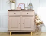 Meuble bas rose poudré, prêt à repeindre, avec deux tiroirs et deux portes. Décoré de fleurs séchées et d'une cage ornementale.