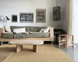 Idée pour fabriquer une table basse originale : un plateau en bois brut aux formes douces, posé sur des pieds minimalistes. Un style épuré pour un salon cosy.
