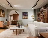 Salon moderne avec canapé blanc texturé, table basse en marbre et bois, et étagère design. Une parfaite illustration de la tendance déco actuelle.