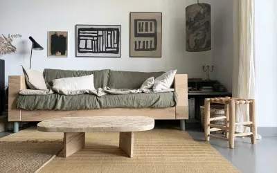 Idée pour fabriquer une table basse originale : un plateau en bois brut aux formes douces, posé sur des pieds minimalistes. Un style épuré pour un salon cosy.