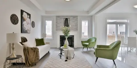 Salon moderne avec canapé blanc, fauteuils verts et cheminée. Idéal pour un conseil décoration intérieur gratuit.