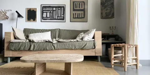Idée pour fabriquer une table basse originale : un plateau en bois brut aux formes douces, posé sur des pieds minimalistes. Un style épuré pour un salon cosy.