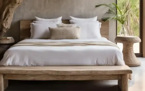 Lit de bois brut, draps blancs immaculés et coussin texturé créent une ambiance de parental chambre boheme chic. Une plante verte apporte une touche de nature.