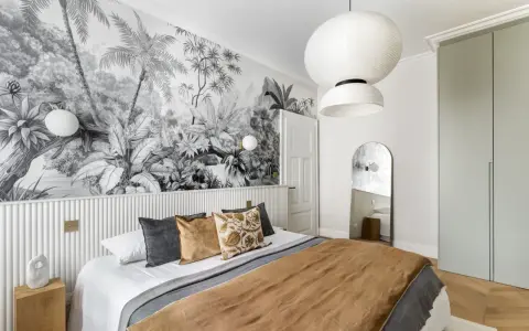 Tête de lit peinture graphique d'une jungle luxuriante en noir et blanc, créant une ambiance tropicale.