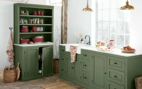 Ambiance rustique pour cette rénovation vieille cuisine. Meubles verts, vaisselle rouge, et lumière naturelle.