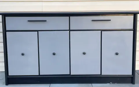 Meuble bas gris et noir avec deux tiroirs et quatre portes. Idéal pour savoir comment vendre ses meubles rapidement.