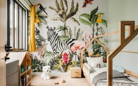Une chambre d'enfant avec un mur jungle : zèbre, flamant rose, léopard, singe, toucan. Une excellente idée déco chambre enfant pour une aventure tropicale !