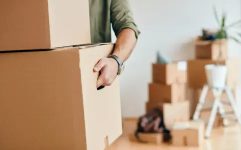 Homme portant des cartons, prêt pour une organisation déménagement longue distance.