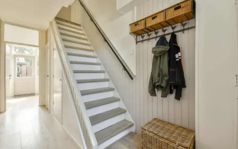 Escalier blanc et gris, avec des marches en bois clair. Une idée pour peindre une cage d'escalier quelle couleur ? Ce style épuré est très tendance.