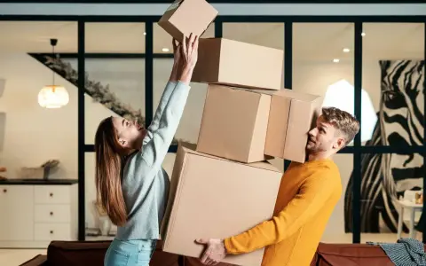 Couple jonglant avec des cartons. Difficile de savoir combien de cartons pour un déménagement quand on est aussi désorganisé !