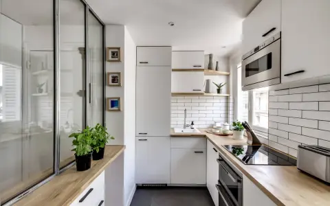 Plan d'une petite cuisine en U moderne et lumineuse, avec des placards blancs, un plan de travail en bois et un carrelage métro.