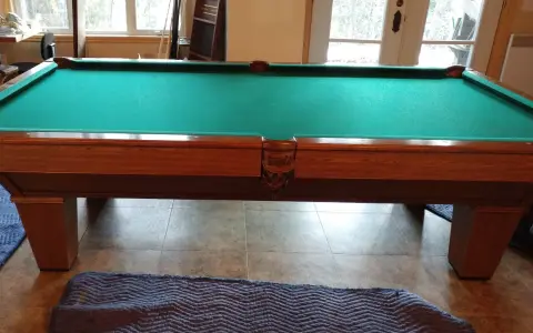 Table de billard français en bois avec tapis vert, prête pour le démontage.