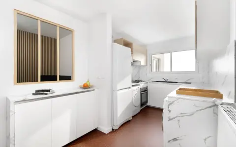 Relooker cuisine avant après : une cuisine moderne et lumineuse avec des meubles blancs, un plan de travail marbré et un sol hexagonal rouge.
